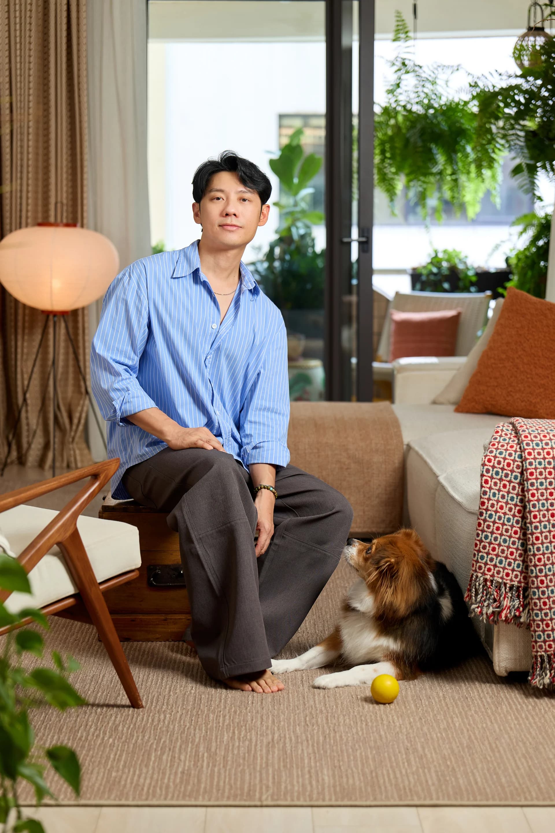 Johannes seated in his living room with his dog beside him